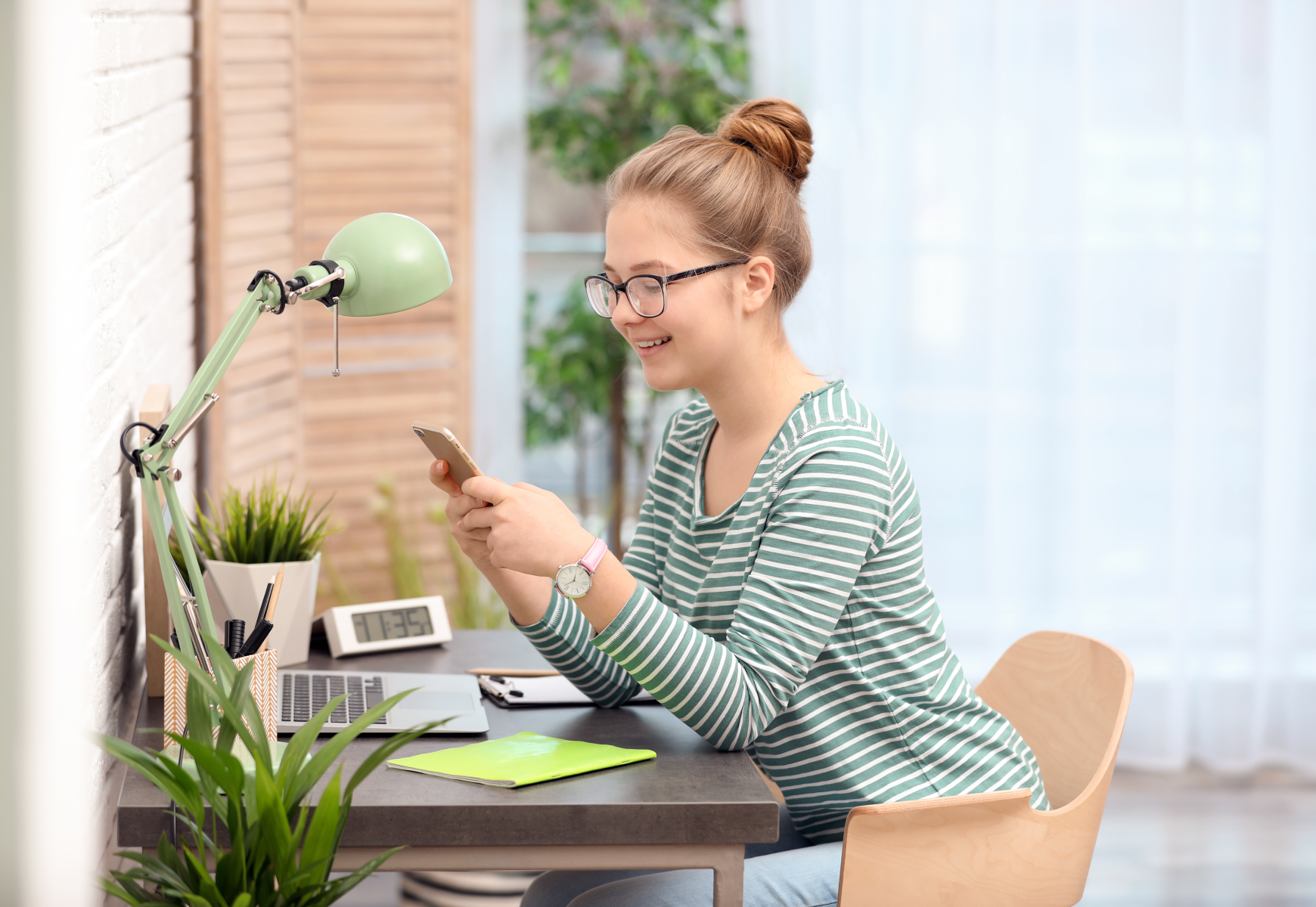 teenage girl studying at table in room